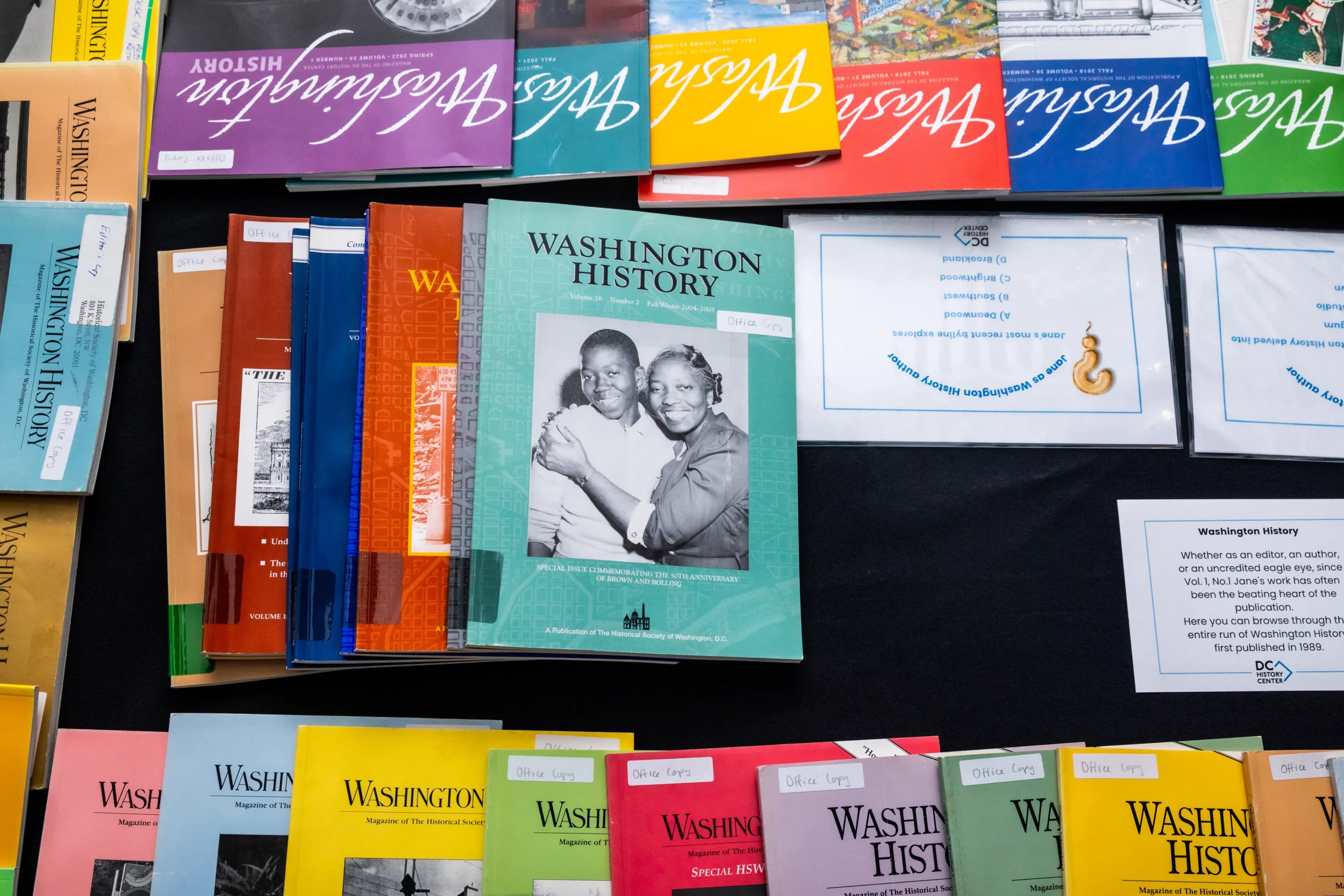 Washington History magazines of various formats and publication dates lay displayed on a table with a black tablecloth.